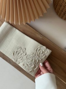 Beige fabric envelope hand-stitched with pearls