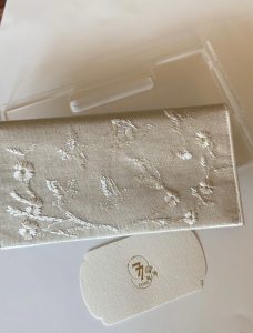 Beige fabric envelope embroidered with roses and birds in off-white