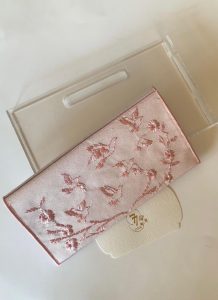 Pink fabric envelope embroidered with roses and birds