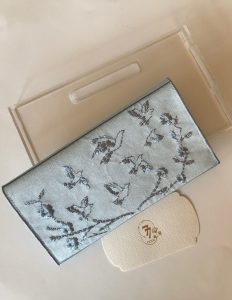 Blue fabric envelope embroidered with roses and birds