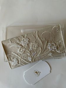 Beige fabric envelope embroidered with off-white roses