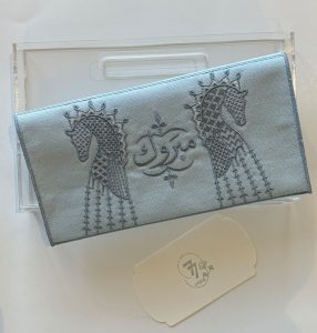 ظرف قماش أزرق مزين بالخيل وكلمة مبروك